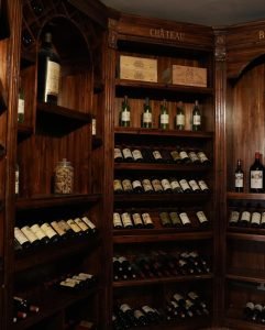 Elegant home wine cellar with wooden racks, neatly organized bottles of red and white wine, and ambient lighting for proper wine storage and aging