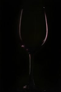 a glass of wine on a black background